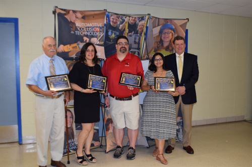 Hall of Achievement winners pose in a group with their plaques